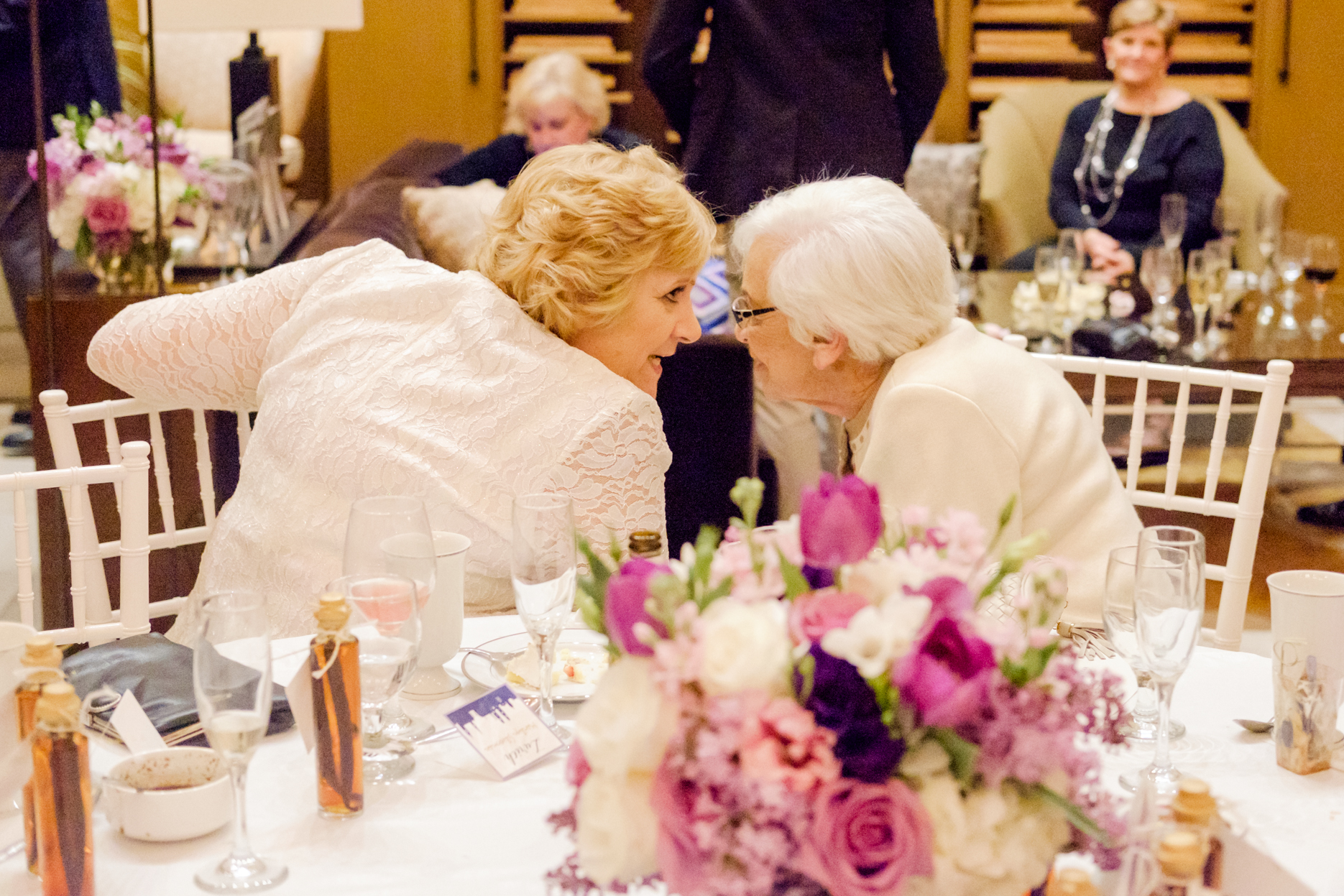 The bride and her mother lean in at a wedding in San Diego.