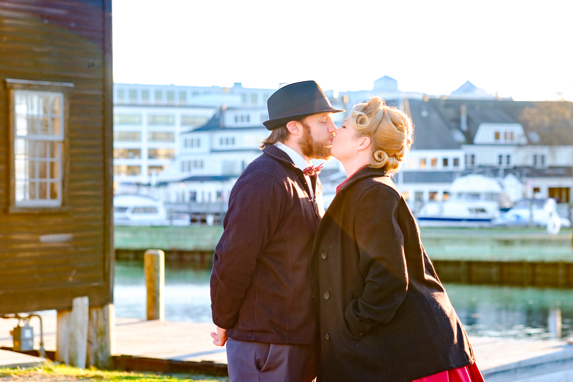 Bride and groom pose for pictures after they get married in the historic house of the seven gables in salem massachusetts. After her elopement, the bride dons a vintage red dress and gorgeous curls in her hair. She has a classic pin up style with red and black accents. Her groom dons a bow tie and a fedora. This North Shore elopement was an intimate wedding and it was an honor to be the photographer for this couple.