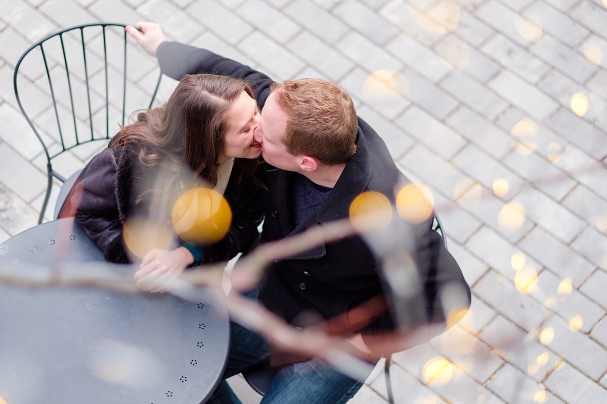 Engaged couple nuzzling under twinkle lights at Bow Market in Union Square