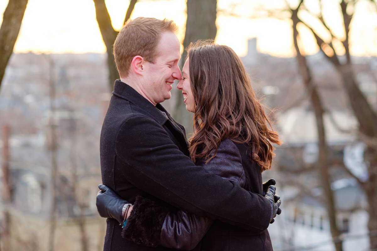 Engaged couple nuzzling in winter in Prospect Hill Park