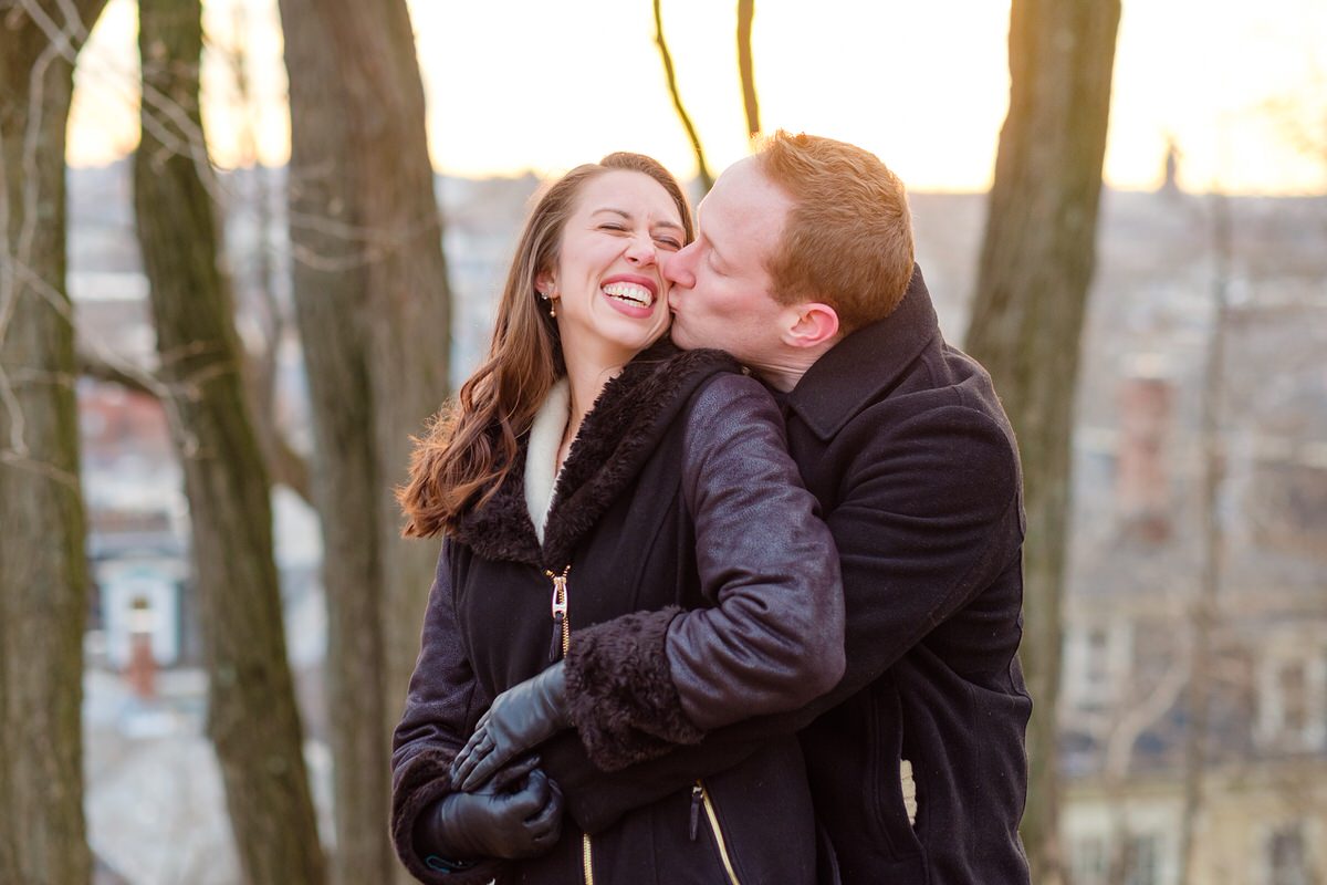 Engaged couple nuzzling in winter in Prospect Hill Park