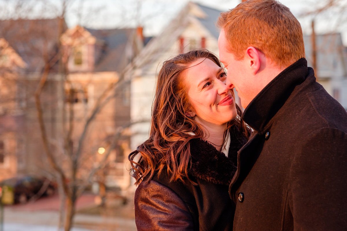 Engaged couple nuzzling in winter in Prospect Hill Park