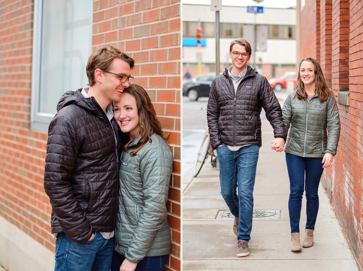 Adorable couple in Patagonia coats walks by a brick wall during a winter engagement session in Davis Square