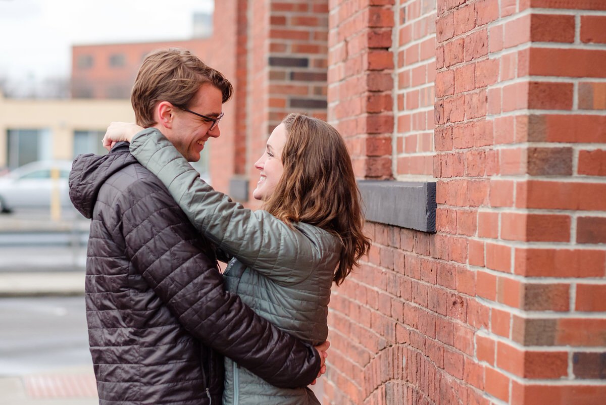 Engaged woman dances with her fiance during a winter engagement session in Massachusetts