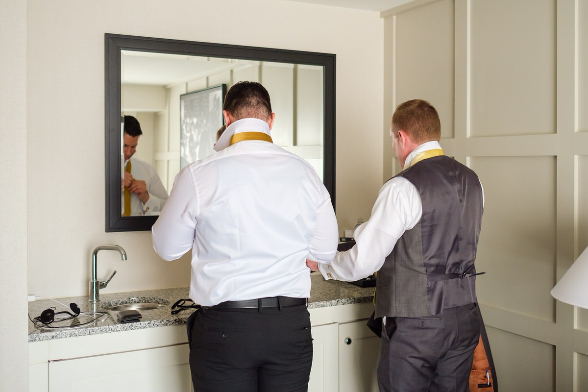 Groom & Groomsman getting ready in the mirror in the Charles Hotel