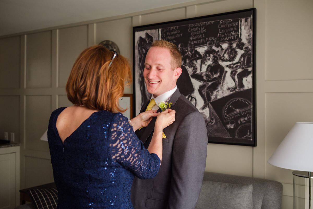 Mom pinning on the groom's boutonniere before his wedding day