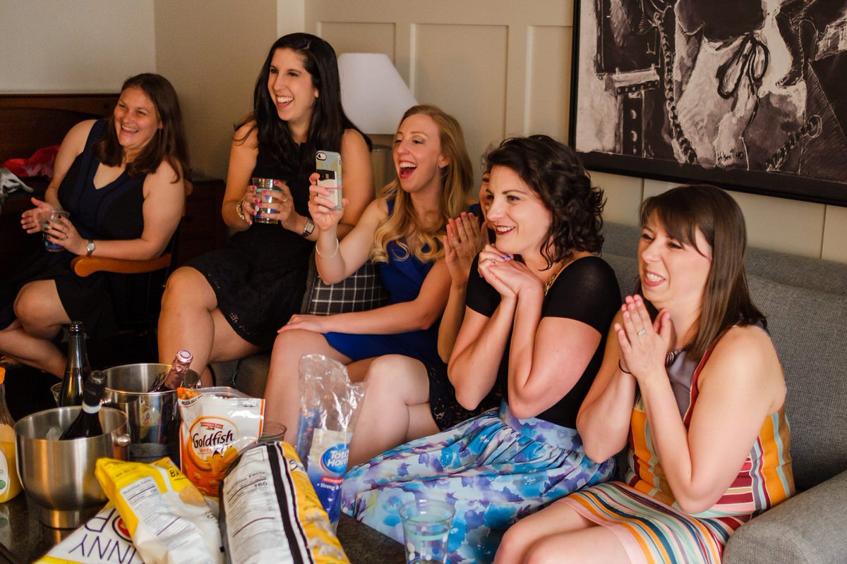 Bride's friends look on as she enters the hotel room