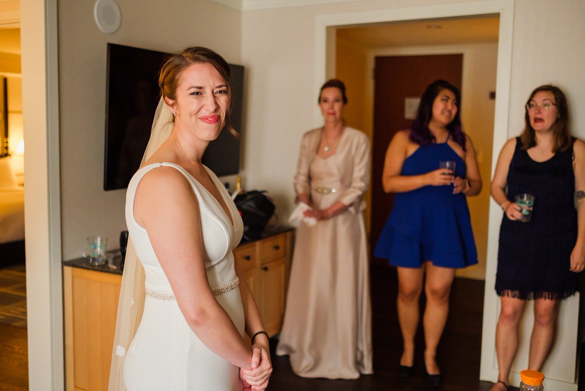 Bride smiles at the camera while getting ready for her wedding