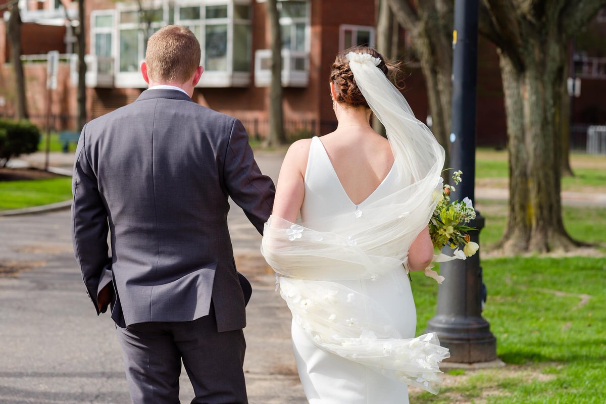 Bride and groom walk in windy park