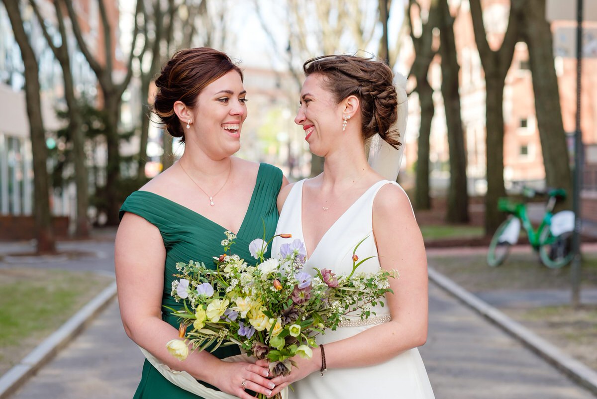 Bride smiles and her sister in a green dress