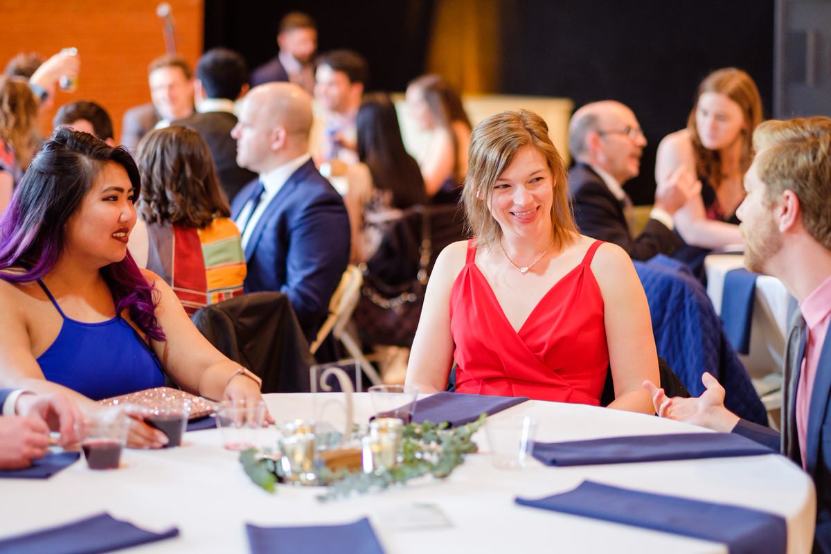 Wedding guest in a red dress smiles