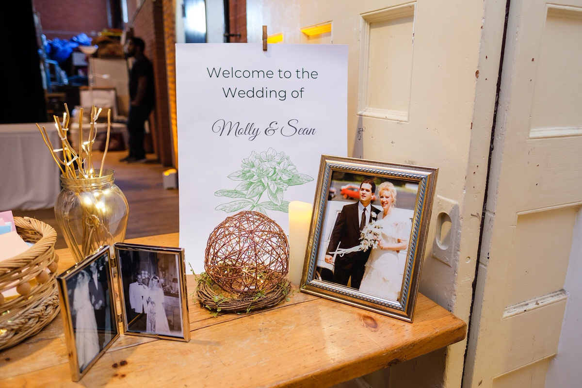 Wedding welcome table with family photos and a sign