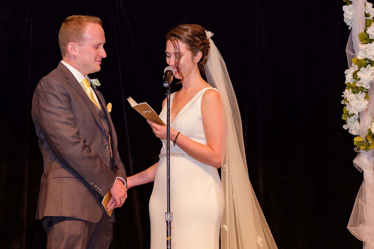 Bride reads vows to her groom from a kraft paper vow book