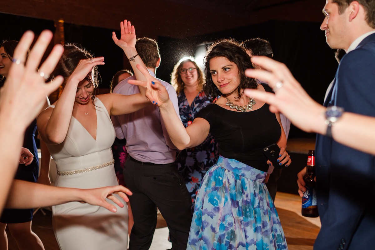 Wedding guests dance and point during the reception at the Somerville Armory in Davis Square