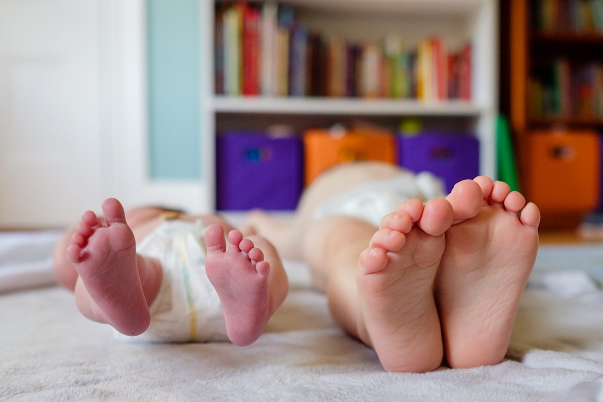 Newborn girl and two year old brother's feet