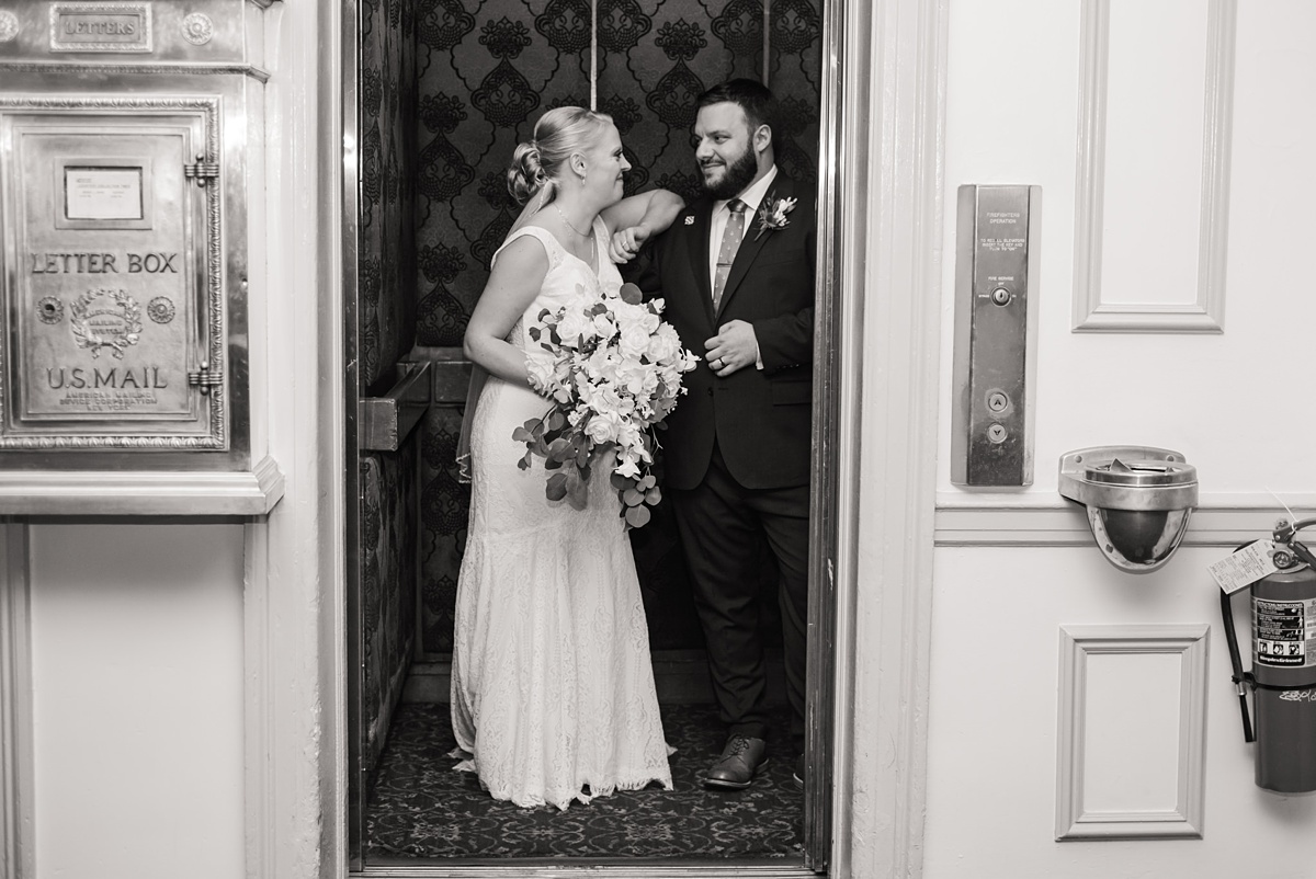 Bride and groom talk in Hawthorne Hotel elevator after wedding ceremony