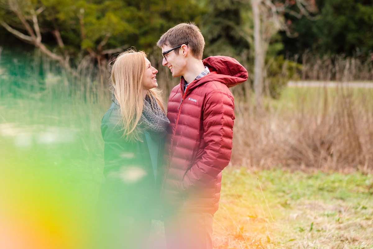 Engaged couple laughs by a river at the Arnold Arboretum in Jamaica Plain