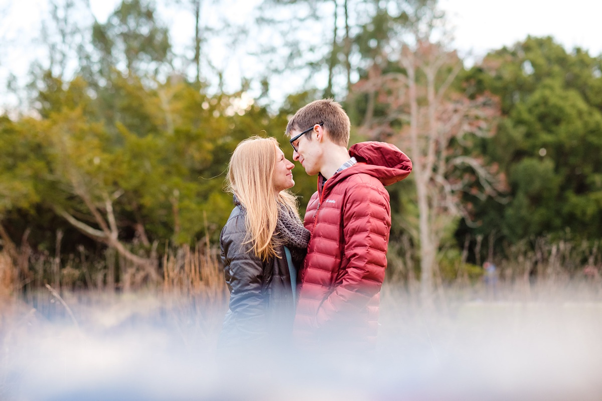 Engaged couple in winter coats poses for photos at the Arnold Arboretum