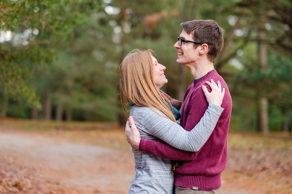 Engaged man and woman laugh on a path in a Boston park