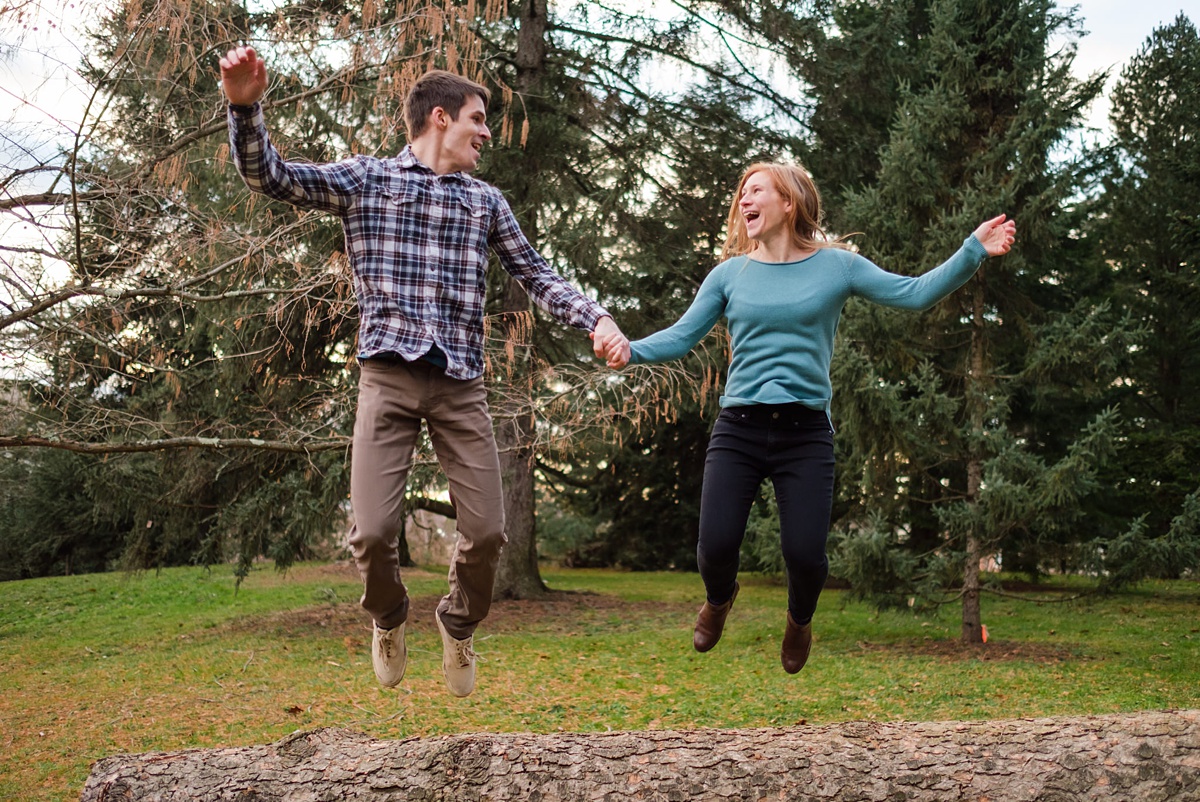 Engaged man and woman jumping in the air the Arnold Arboretum in Boston