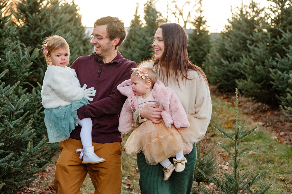 Boston Christmas tree farm photoshoot of family walking and laughing at golden hour